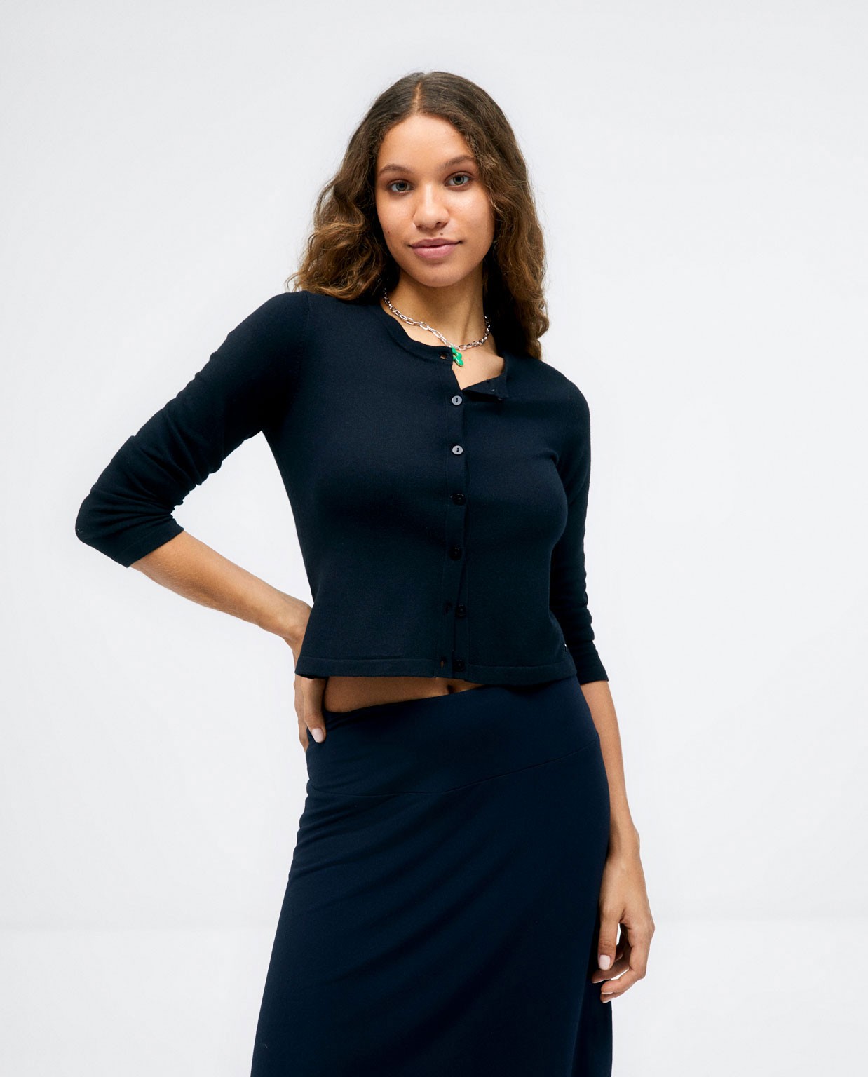 Short knitted cardigan with long sleeves. Plain. Black
